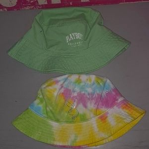 2 Playboy Bucket Hats one is rainbow tie-dye and the other is sage green